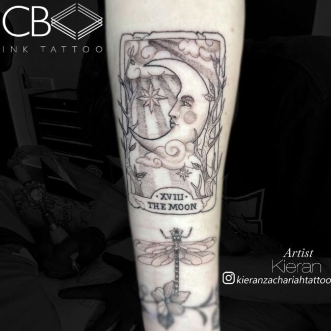Kieran Tattoo Artist Neo Traditional Black and Grey Card Moon with Writing and Roman Numerology Forearm Tattoo