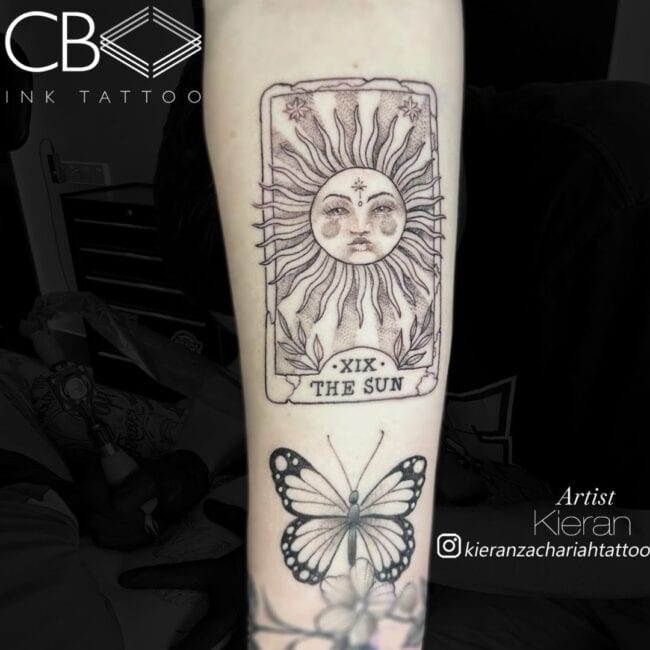 Kieran Tattoo Artist Neo Traditional Black and Grey Card Sun with Writing and Roman Numerology Forearm Tattoo