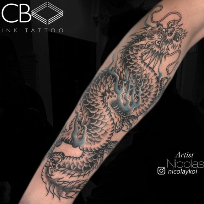 Nicolas Tattoo Artist Traditional Colour Detailed Dragon Detailed Scales Detailed Head and Face With Blue Flames Surrounding The Body of The Dragon Forearm Tattoo