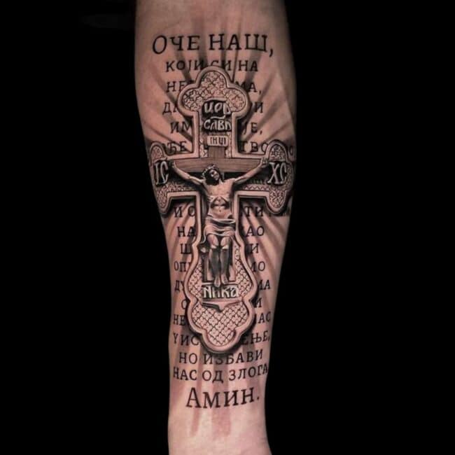 Penno Tattoo Artist Realism Black and Grey Orthodox Christian Cross with Jesus with Cyrillic Text in The Background Forearm Tattoo