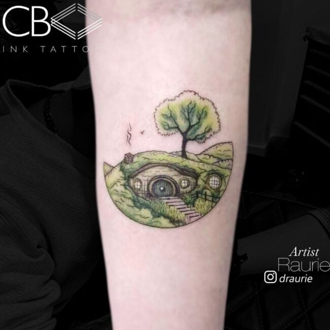 Raurie Tattoo Artist Cartoon Colour Realism Hobbit Hole Smoke Chimney Tree The Lord of The Rings Forearm Tattoo