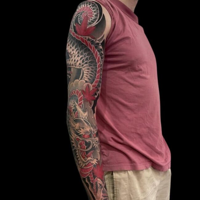 Rhys Tattoo Artist Neo Traditional Japanese Colour Detailed Dragon on Motion Dragon Roar Talons Leaves Scales Black Shadow Background Arm Sleeve Tattoo