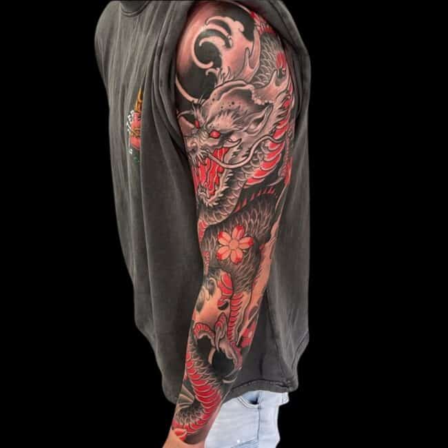 Rhys Tattoo Artist Neo Traditional Japanese Colour Detailed Dragon on Motion Dragon Rorar Talons Flowers Scales Black Shadow Background Arm Sleeve Tattoo