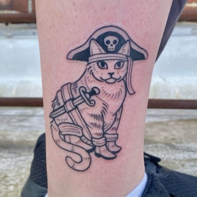 Black and Grey Fine Line Neo Traditional Pirate Cat Quirky and Fun with Sword Tricorn Hat Skull Boots Pirate Bandana Forehead Leg Tattoo