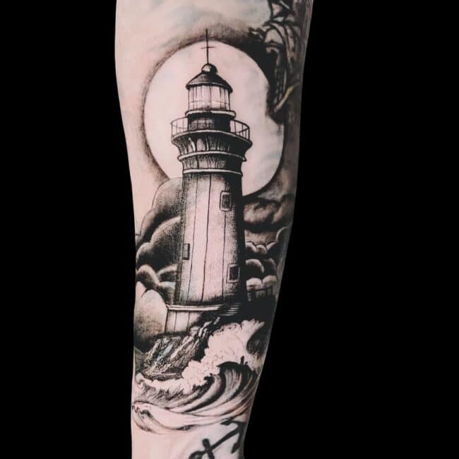 Juan Tattoo Artist Black and Grey Realism Lighthouse Beaten by Sea Ocean Waves Storm Moon in the Background Forearm Tattoo