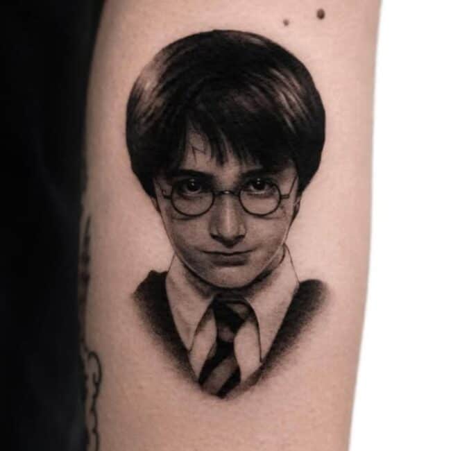 Realism Black and Grey Portrait Harry Potter Round Glasses Scar on Forehead Wearing Gryffindor Tie Forearm Tattoo