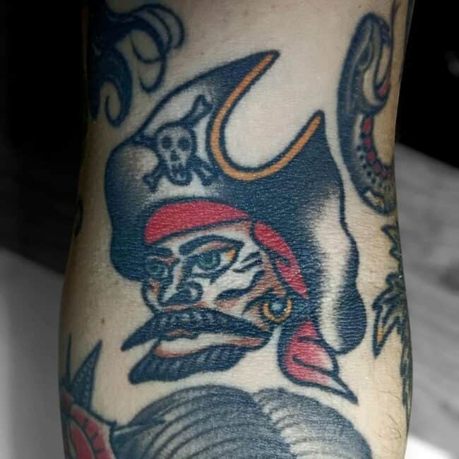 Traditional Colour Pirate with Mustache Beard Sharp Eyes Skull on His Pirate Cap Forearm Tattoo