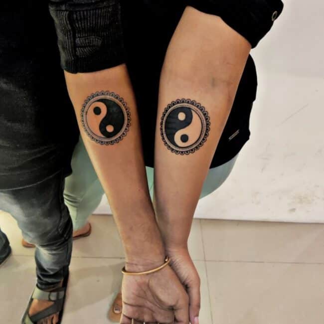 Black and Grey Geometric Mandala Yin Yang Detailed Borders Resembling Petals Small Dots Forearm Matching Tattoo