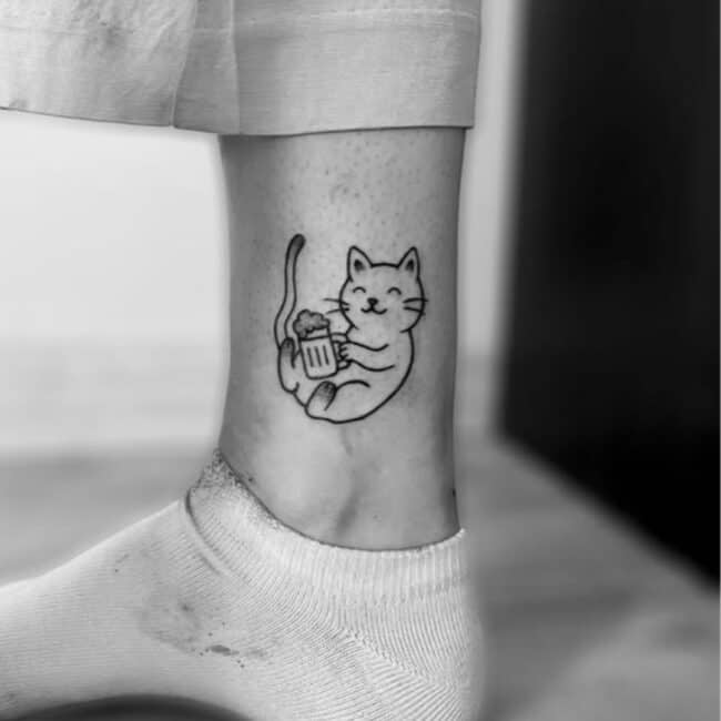 Black and Grey Minimalist Fine Line Playful Cat Holding a Beer Bubbles Glass Eyes Tail Front Legs Sitting Smiling Nose Lips Whiskers Ears Leg Ankle Tattoo