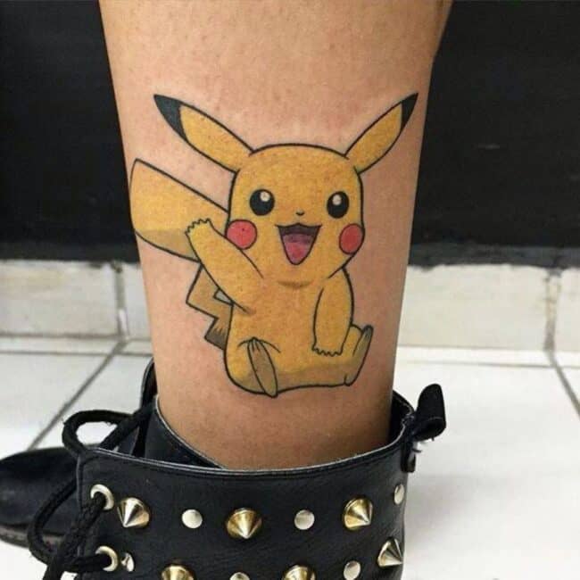 Colour Anime Cartoon Pikachu Big Smile Raising One Hand Sitting Round Red Electric Cheek Round Eyes Pointed Ears Lightning Bolt Tail Leg Ankle Tattoo,Pokémon Tattoo Ideas
