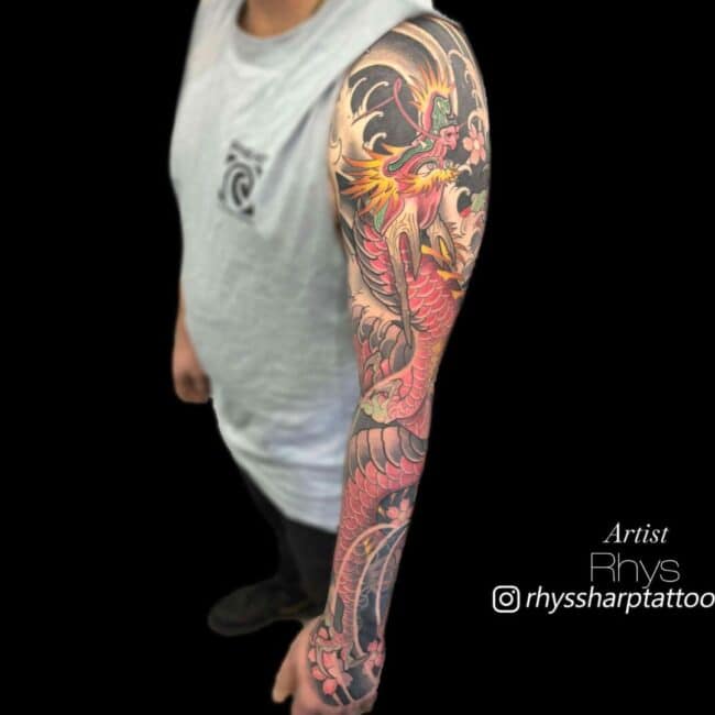 Rhys Tattoo Artist Traditional Japanese Colour Full Body Pink Red Dragon Sharp Claws Paws Teeth Horns Scales Detailed Eyes Nose Mouth Burning Flames Wave Pattern Arm Sleeve Tattoo