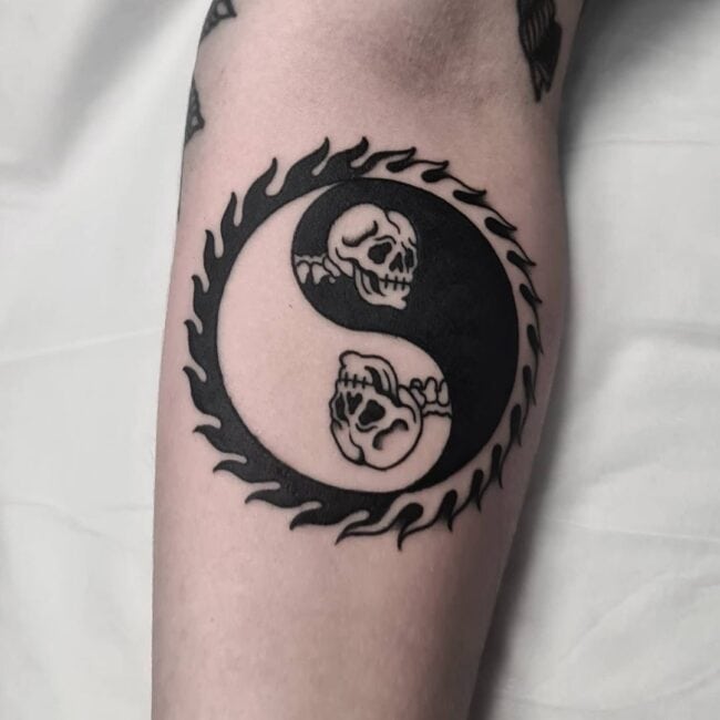 Traditional Blackwork Yin Yang Ring of Flames Two Skulls Facing Left and Right Detailed Eye Sockets Teeth Cranial Sutures Forearm Tattoo