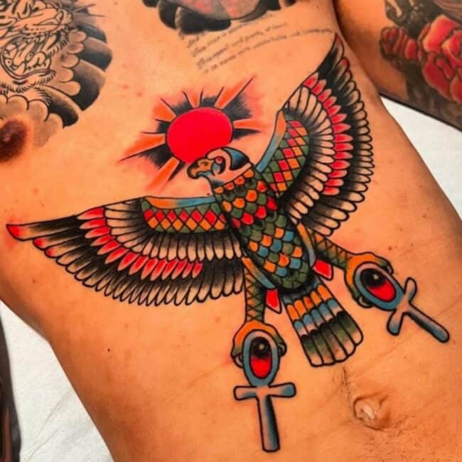 Traditional Colour Falcon Bird Ancient Egyptian Symbol Bold Ankh Shaped Cross Loop Sun Backdrop Detailed Wings Beak Eye Tail Abdomen Ribs Belly Sternum Tattoo