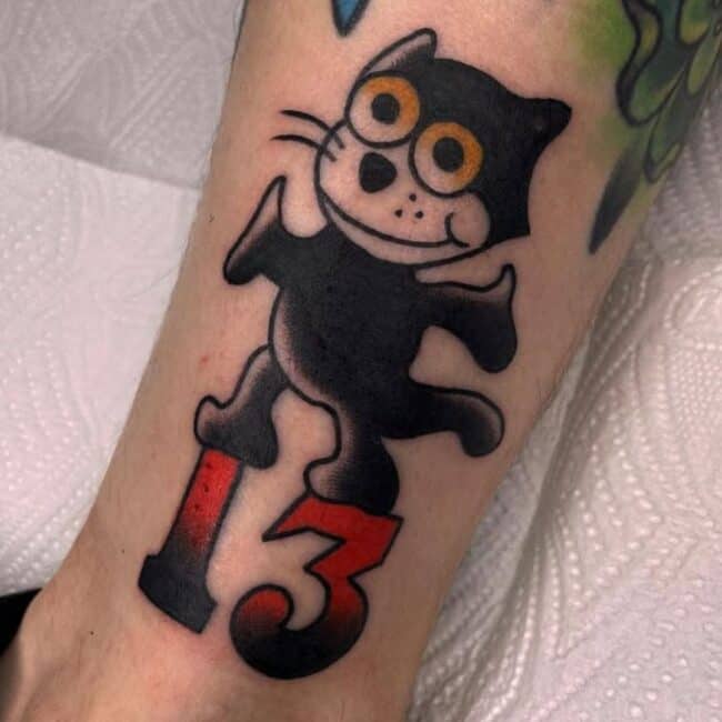Traditional Colour Cartoon Felix Whole Body Cat with Bold Lines Big Eyes Smiling Whiskers Cheeks Standing in Number Thirteen Leg Calf Tattoo