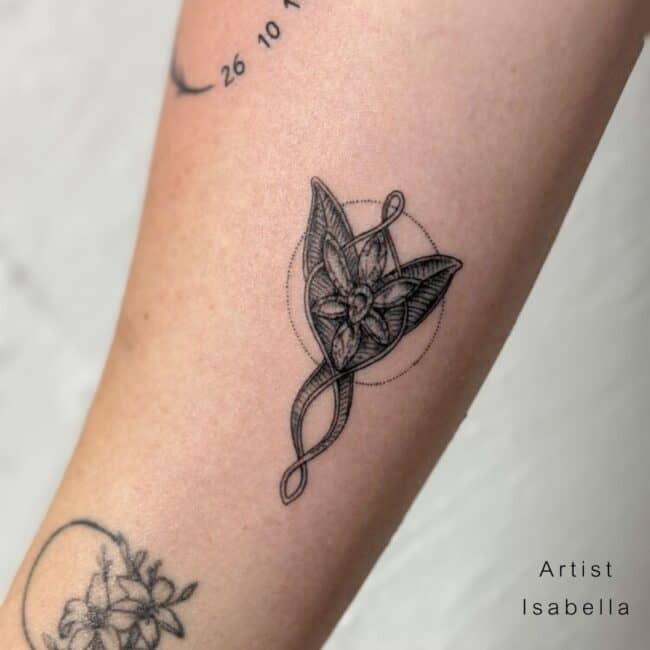 Isabella Tattoo Artist Black and Grey Fine Line Realism Pendant Evenstar Lord of the Rings Leaves Flowers Petal Diamond Pattern Round Dots Forearm Tattoo
