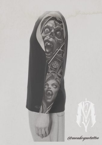 A person wearing a black sleeveless top displays a detailed black-and-grey tattoo sleeve with screaming faces and geometric patterns on their left arm. The artist’s watermark and Instagram handle are visible in the lower right corner. | CB Ink Tattoo